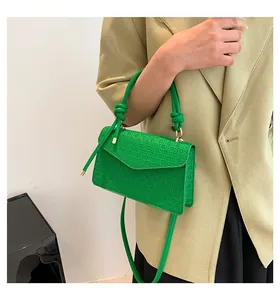 Detail view of vibrant green vintage textured crossbody handbag with unique knotted handle