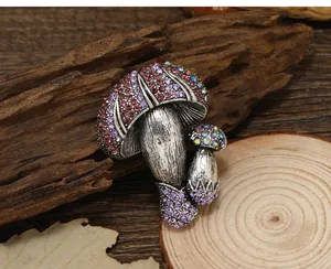 Detail of a vintage mushroom brooch with colorful rhinestones on a rustic wood background