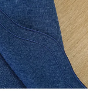 Gros plan macro montrant la texture brodée haut de gamme d'un set de table en coton et lin bleu