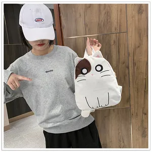 Cute white canvas cat backpack with 3D ears shown held by a girl in casual wear