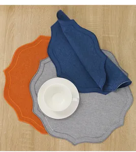 Vue détaillée de sets de table festonnés en coton et lin avec broderie en trois couleurs.