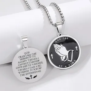 Close-up detail view of stainless steel praying hands pendant with engraved prayer text