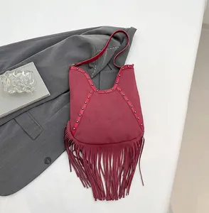 Detail of burgundy fringe hobo bag with metallic studs and sun embossed pattern