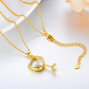 Close-up detail of elegant gold wine glass pendant necklace with cubic zirconia stone