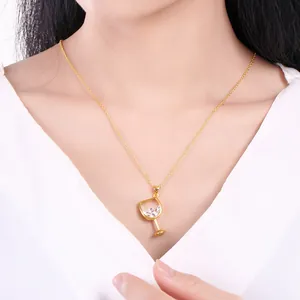 Elegant gold wine glass pendant necklace featuring a sparkling zircon worn by model