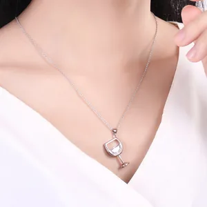 Detail of elegant silver red wine glass pendant necklace with clear zircon on model