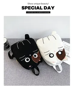 Close-up detail of cute Japanese style canvas cat backpacks in black and white colors