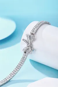 Elegant detail shot of a double-row sparkling diamond bracelet with a bow charm.