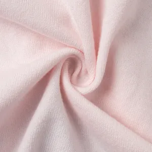 Primo piano della morbida trama in maglia rosa che mostra i dettagli del materiale