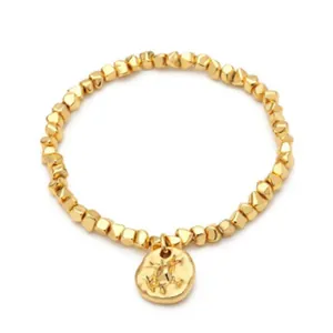 Detail of 18K gold plated bracelet featuring irregular beads and round pendant
