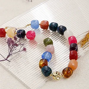 Gros plan d'un collier de perles en résine colorées de style bohème sur plateau