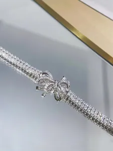 Detailed view of an elegant silver ribbon bow bracelet with shimmering crystals.
