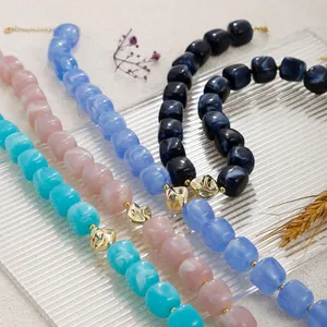 Gros plan de colliers bohèmes en perles de résine multicolores et détails dorés