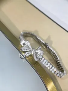 Detailed macro shot of an elegant sparkling ribbon bow bracelet with clear pavé stones
