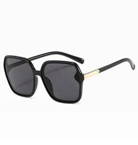 Moderne schwarze Oversize-Sonnenbrille mit goldenen Metallbügeln und UV400-Gläsern