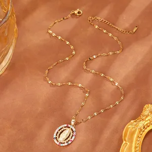 Detailed macro shot of a gold Virgin Mary necklace with colorful zircons on textured background