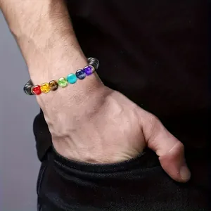 Detailed shot of men's natural obsidian beaded bracelet featuring colorful chakra stones.