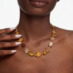Vue détaillée d'un collier floral vintage de luxe avec cristaux ambrés sur modèle.