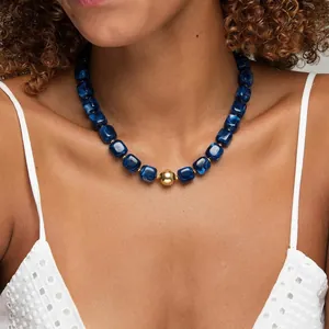 Collier bohème élégant en perles de résine bleue avec un accent de sphère dorée