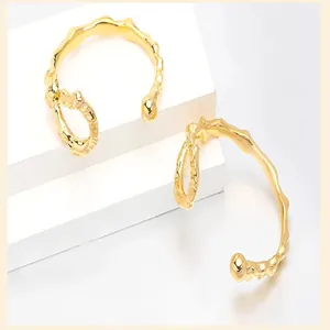Detailed macro view of 18K gold plated irregular knotted design open cuff bracelets.