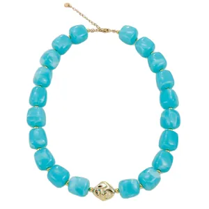 Collier bohème avec de grosses perles en résine turquoise et un accent en métal doré