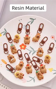Detailed view of various cute resin Capybara keychains with colorful hats and bow ties