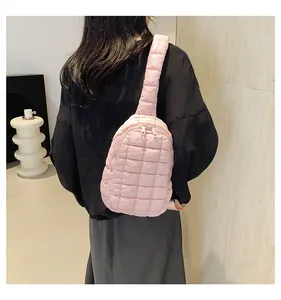 Vista dettagliata di una borsa a tracolla trapuntata rosa in nylon su una modella