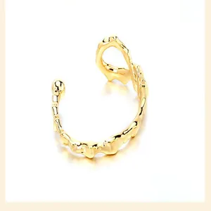Close-up of irregular 18K gold plated open cuff with unique lava texture detail