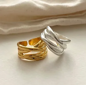 Close-up of elegant irregular intertwined gold and silver rings with glossy finish