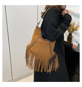 Vintage Bohemian tan fringe shoulder bag with sun embossing and metal stud details.