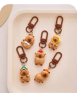 Set of five cute cartoon capybara resin keychains with diverse hat designs for bags.