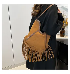 Detailed view of brown Bohemian fringe tote bag featuring sun embossing and metal studs.