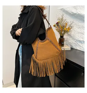 Chic bohemian fringe shoulder bag with sun-embossed pattern and silver studs.