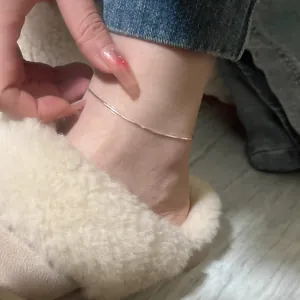 Close-up detail of a minimalist 925 silver snake chain anklet worn on the ankle.