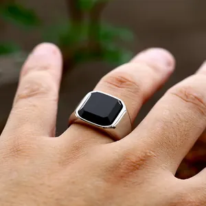 Macro detail of a men's vintage silver ring with a square black agate stone inlay