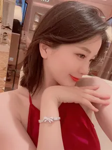 Elegant silver bow-knot bracelet featuring sparkling crystals on a female model wrist