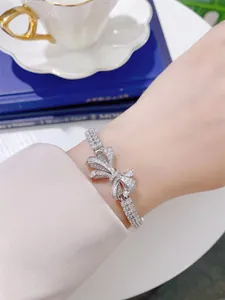 Detailed view of a silver ribbon bow bracelet with sparkling pavé cubic zirconia.