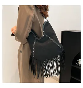 Detailed view of black Bohemian fringed tote bag with sun embroidery and studs