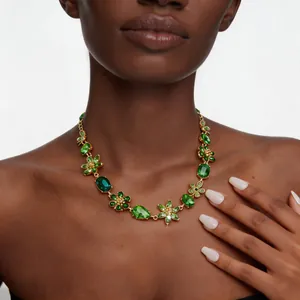 Exquis collier de fleurs en pierres précieuses vertes porté par un mannequin chic