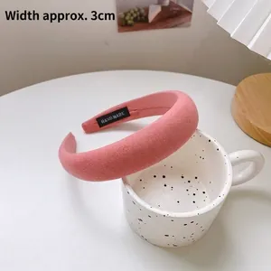 Gros plan d'un serre-tête en éponge rose rembourré avec une largeur de 3 cm pour cheveux.