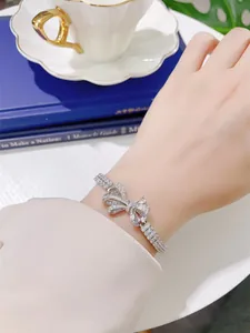 Detailed macro view of an elegant S925 silver ribbon bow bracelet with pavé-set crystals.