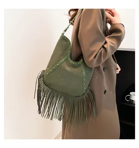 Bohemian green fringe shoulder bag featuring metal studs and embossed sun pattern detail
