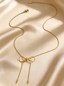 Elegant gold-tone stainless steel bow-knot necklace displayed on soft cream satin fabric