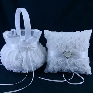 Close-up of elegant white fabric rose wedding flower basket and ring bearer pillow set