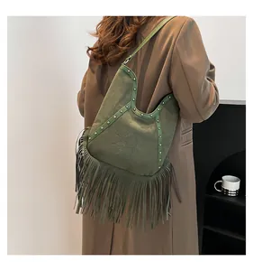 Vintage green Bohemian fringe tote bag worn on shoulder for a stylish retro look