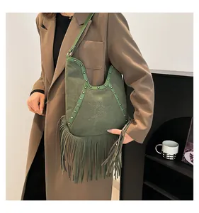 Detail of green suede fringe shoulder bag featuring bohemian sun pattern engraving