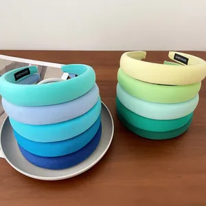 Divers serre-têtes rembourrés couleurs bonbon empilés sur table pour tête haute