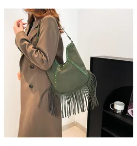 Stylish green vintage fringe shoulder bag with bohemian stud details shown in use.