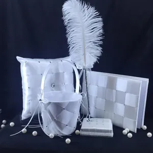 Elegant white satin wedding set including flower girl basket, ring pillow and guest book.