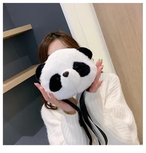 Cute plush panda crossbody bag for girls being held by a model in a cozy setting.
